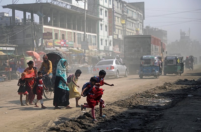 Schoolchildren cross a dusty road in Dhaka, Bangladesh March 4, 2018. (Reuters Photo)
