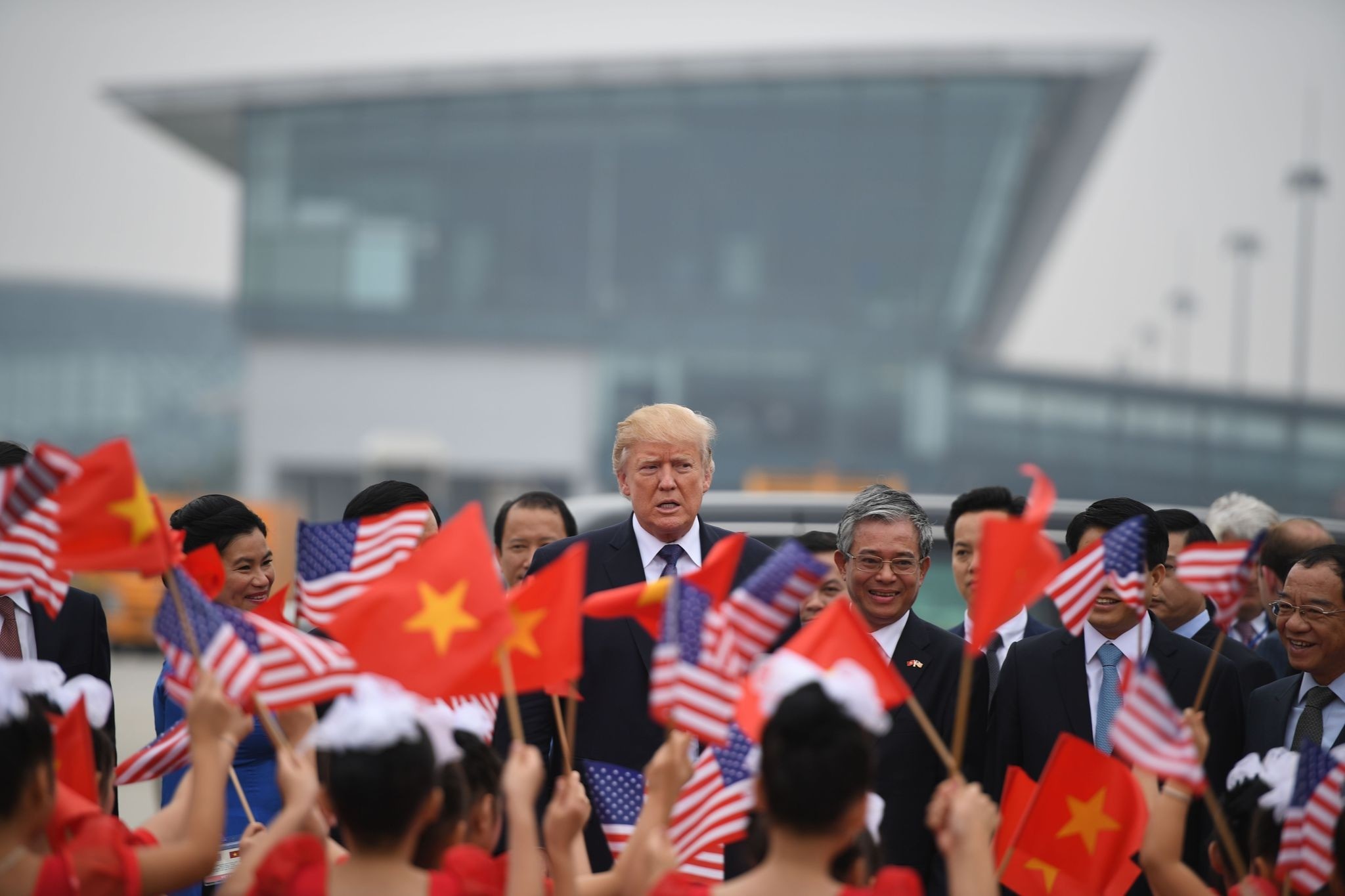  President Donald Trump watches as young girls wave U.S. and Vietnamese national flags before boarding Air Force One to depart to the Philippines, at the airport in Hanoi, Vietnam, Nov. 12. 