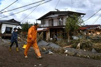 Residents walking past flood-damaged houses in Nagano, after Typhoon Hagibis hit Japan, Oct. 15, 2019. (AFP)