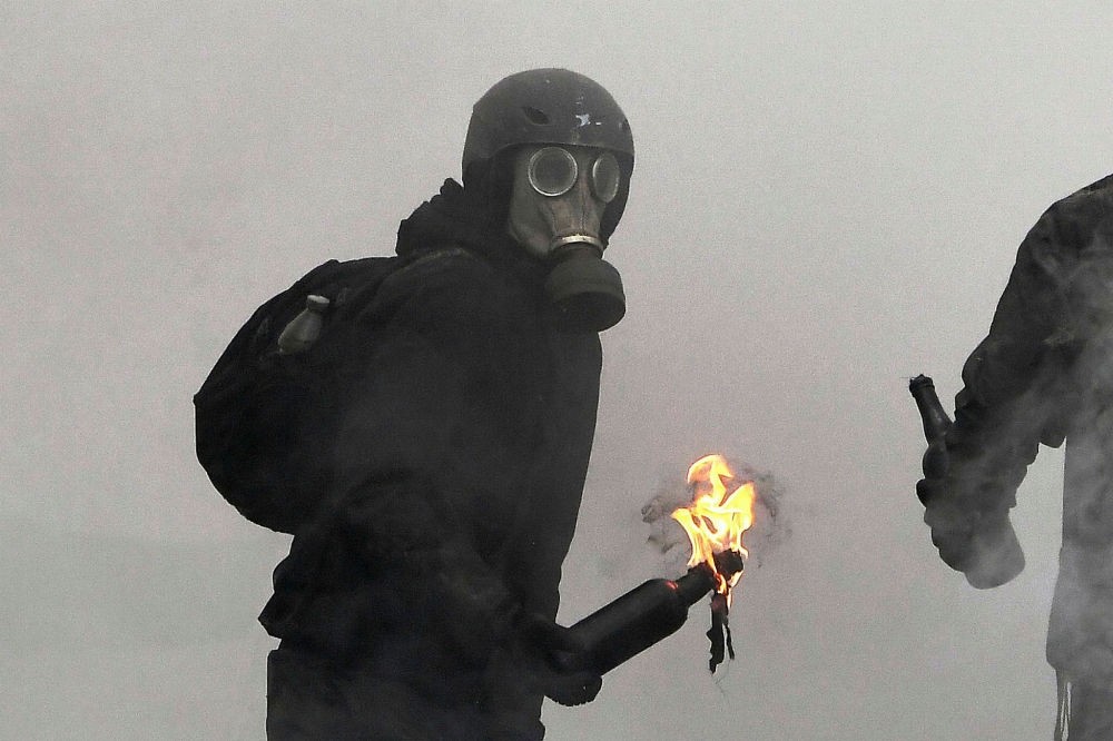 An anarchist protester throws a Molotov cocktail as clashes erupt during the Gendarmerie operation to raze the squat camp at Notre-Dame-des-Landes, April 10.