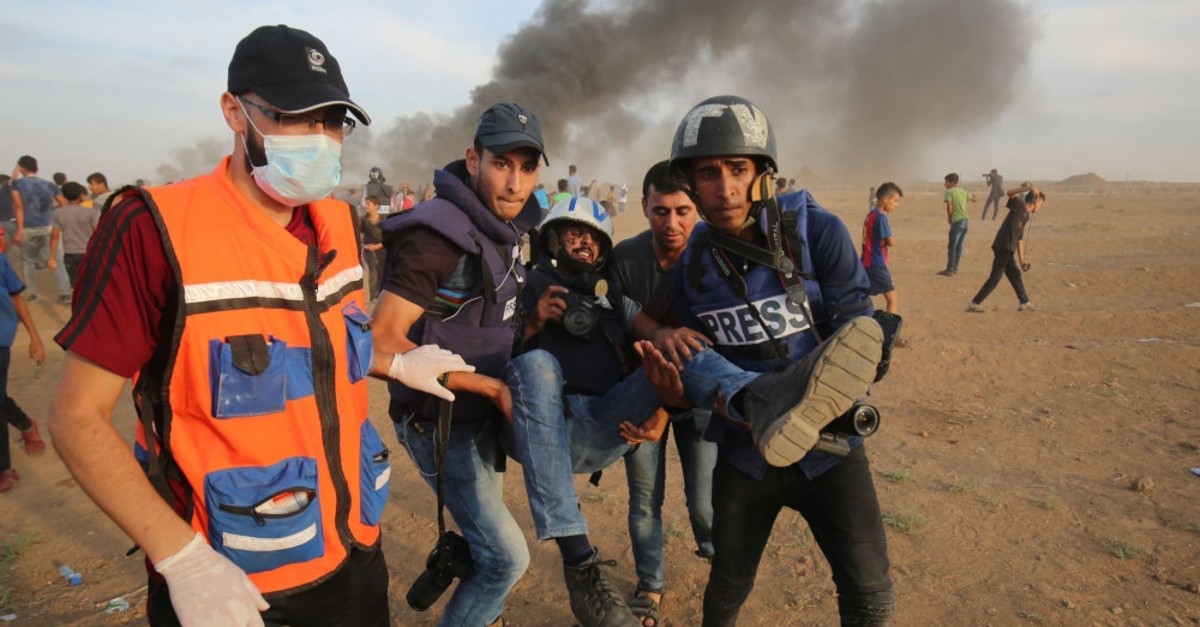 Palestinian paramedics and journalists carry a wounded fellow journalist during clashes with Israeli forces, Gaza Strip, Nov. 5, 2018.
