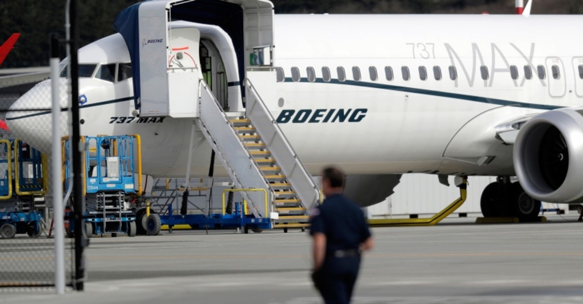 In this March 14, 2019, file photo a worker walks next to a Boeing 737 MAX 8 airplane parked at Boeing Field in Seattle. (AP Photo)