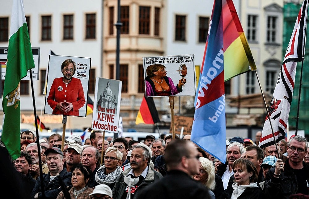 Supporters of the 'Pegida' movement and German right-wing populist party AfD gather at a demonstration infront of the Frauenkirche church in Dresden, Germany, 18 September 2017. (EPA Photo)