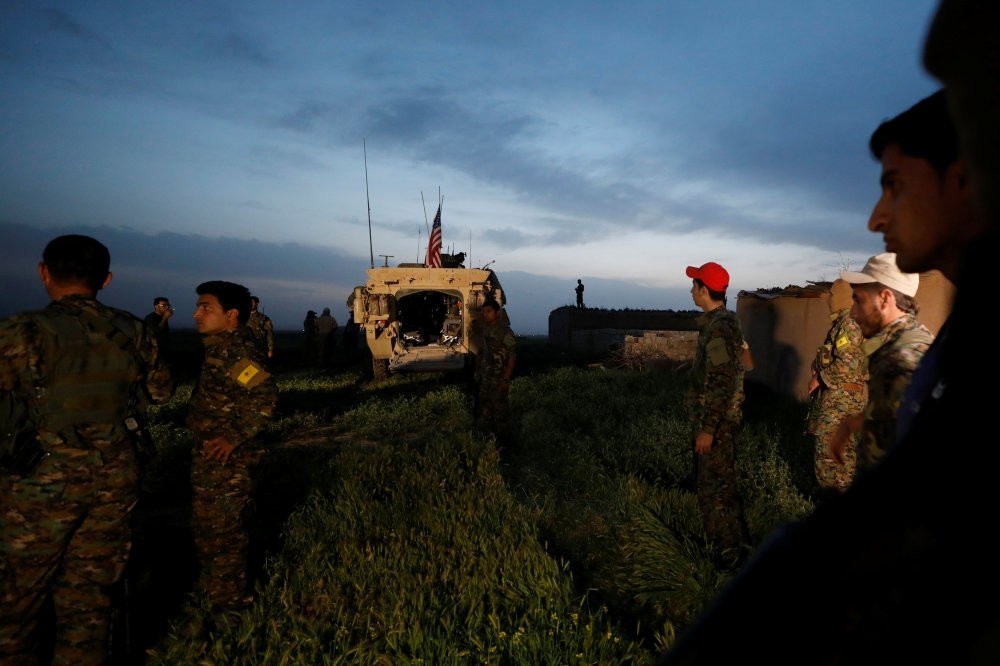 Kurdish YPG terrorists standing near a U.S military vehicle in the Syrian town of Darbasiya next to the Turkish border, April 28. 