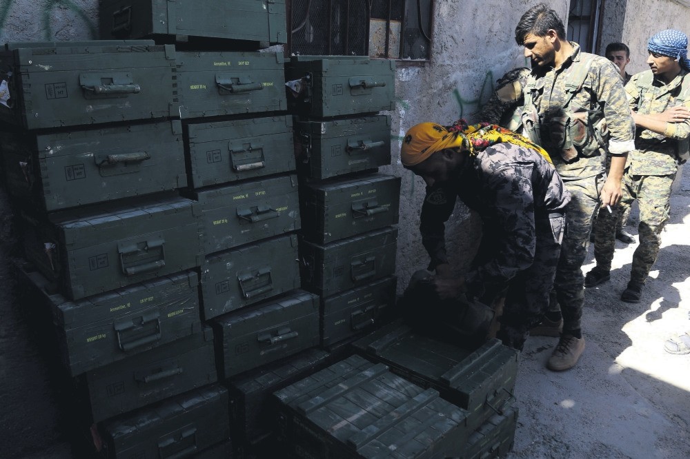 YPG-led Syrian Democratic Forces (SDF) unload boxes of ammunition supplied by the U.S.-led coalition in a village north of Raqqa, June 7, 2017.