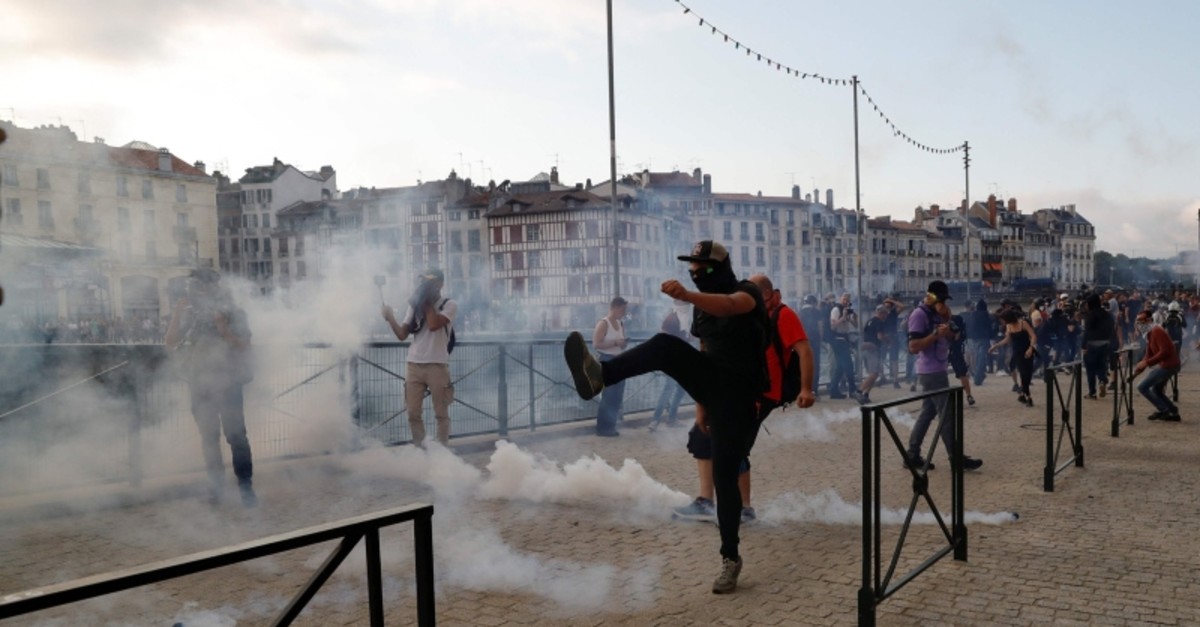A protester kicks away a 'canister' fired by French security personnel during a demonstration in the city of Bayonne, south-west France on Aug. 24, 2019 (AFP Photo)