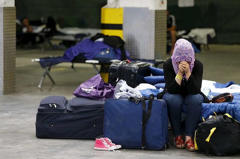 A Syrian woman cries as she sits on a folding bed in a former newspaper printing house used as a refugee registration centre for the German state of Hesse in Neu-Isenburg, on the outskirts of Frankfurt, Germany, September 11, 2015. (Reuters Photo)