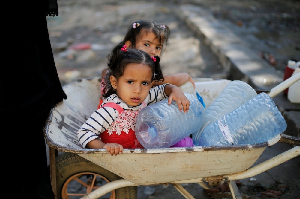 Girls wait next to a tap where people collect drinking water, Sanaa, Nov. 5.