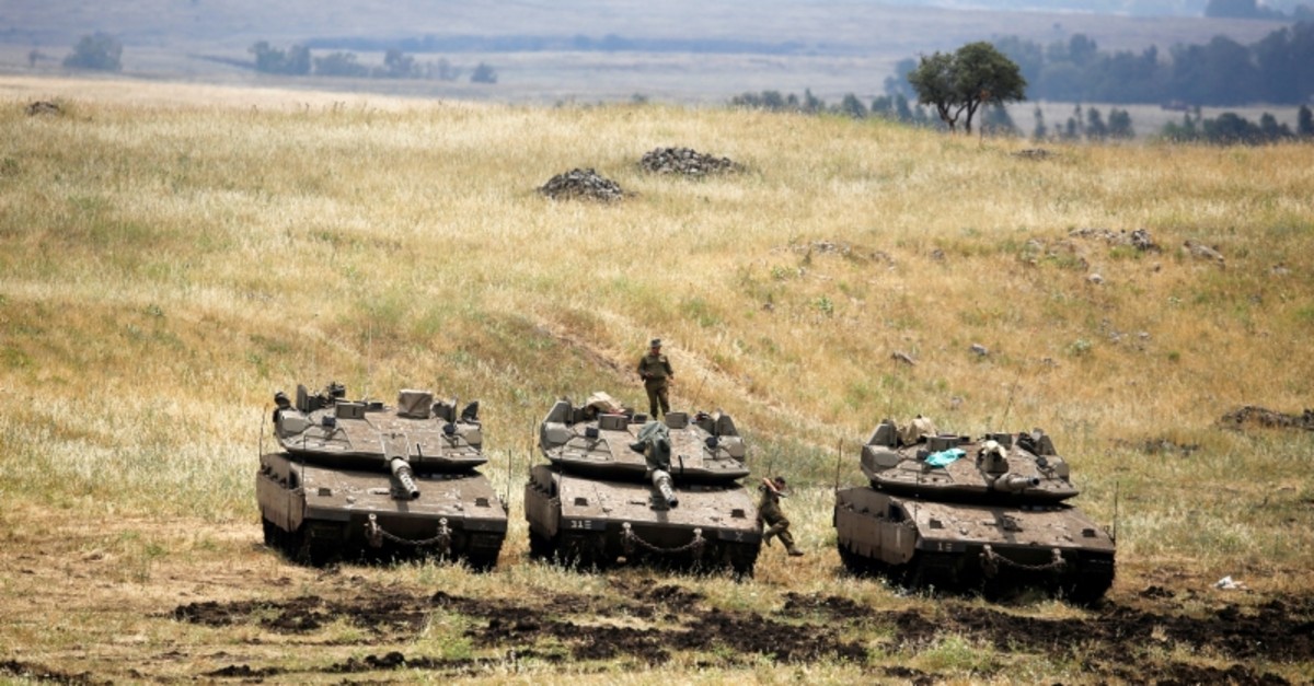 An Israeli soldier stands on a tank as another jumps off it near the Israeli side of the border with Syria in the Israeli-occupied Golan Heights, Israel, May 9, 2018. (REUTERS Photo)