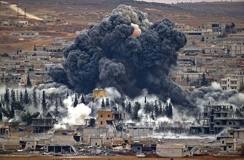 In this Nov. 17, 2014 file photo, smoke rises from the Syrian city of Kobani, following an airstrike by the US led coalition, seen from a hilltop outside Suruc, on the Turkey-Syria border. (AP Photo)