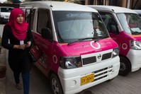 A driver with the women-only Paxi Pakistan taxi company walks past a Pink Taxi during a launch ceremony in Karachi on International Womenu2019s Day.