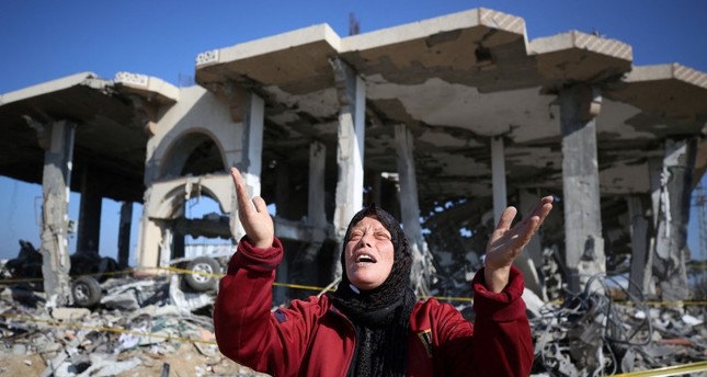 امرأة فلسطينية أمام منزل مدمر في قطاع غزة. 16/01/2024 الفرنسية