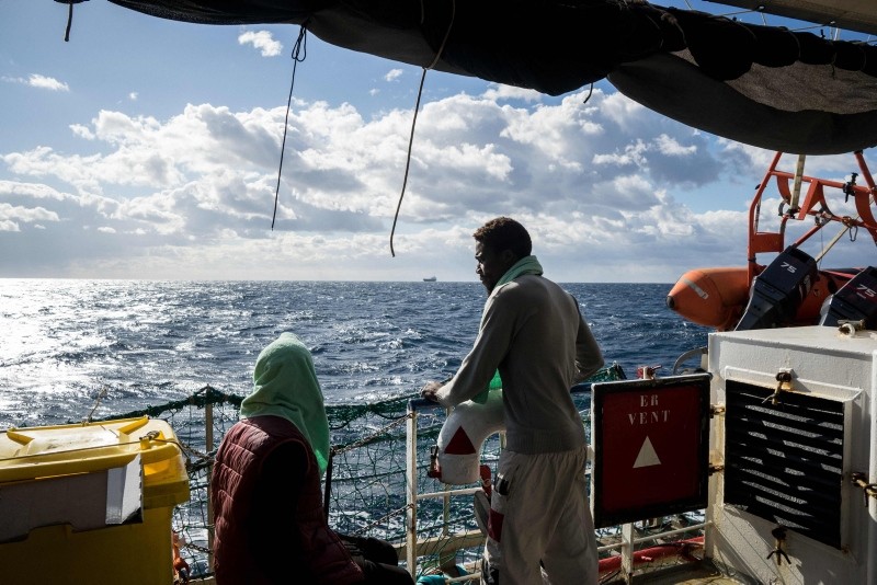 Rescued migants rest in the sun after a cold night onboard the Dutch-flagged rescue vessel Sea Watch 3 on January 5, 2019 (AFP Photo)