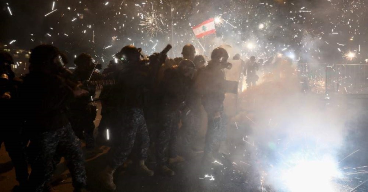 Lebanese police react to fireworks hurled toward them by anti-government protesters in the downtown district of the capital Beirut, near the country's parliament building on January 18, 2020. (AFP Photo)
