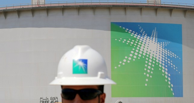 موظف في شركة أرامكو يسير أمام إحدى خزانات النفط في السعودية رويترز