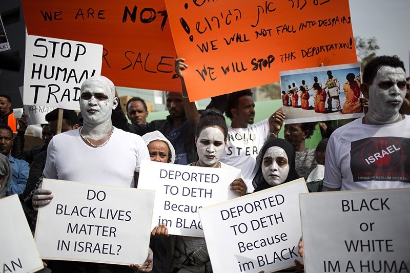African migrants hold signs during a protest in front of Rwanda embassy in Herzeliya, Wednesday, Feb. 7, 2018. (AP Photo)