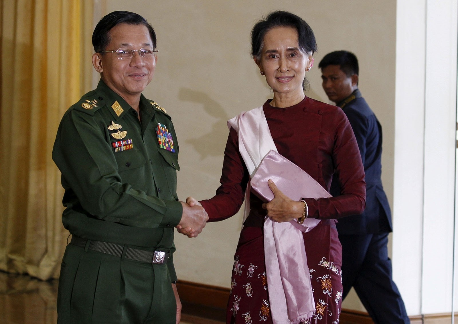Senior General Min Aung Hlaing (L), Myanmar's commander-in-chief, shakes hands with National League for Democracy (NLD) party leader Aung San Suu Kyi before their meeting in Hlaing's office at Naypyitaw December 2, 2015.