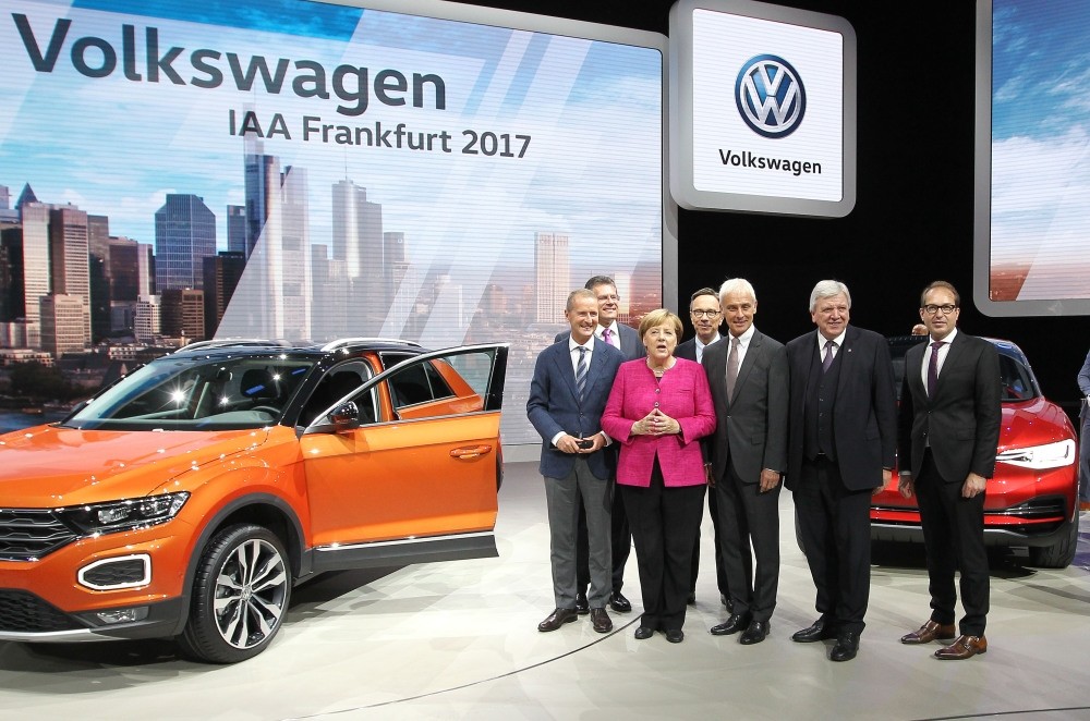 Angela Merkel and Volkswagen CEO Matthias Mueller (3rdR), and the other officials stand next to a VW T-Roc car as they visit the booth of Volkswagen during her inauguration tour of Internationale Automobil auto show, yesterday in Frankfurt am Main.