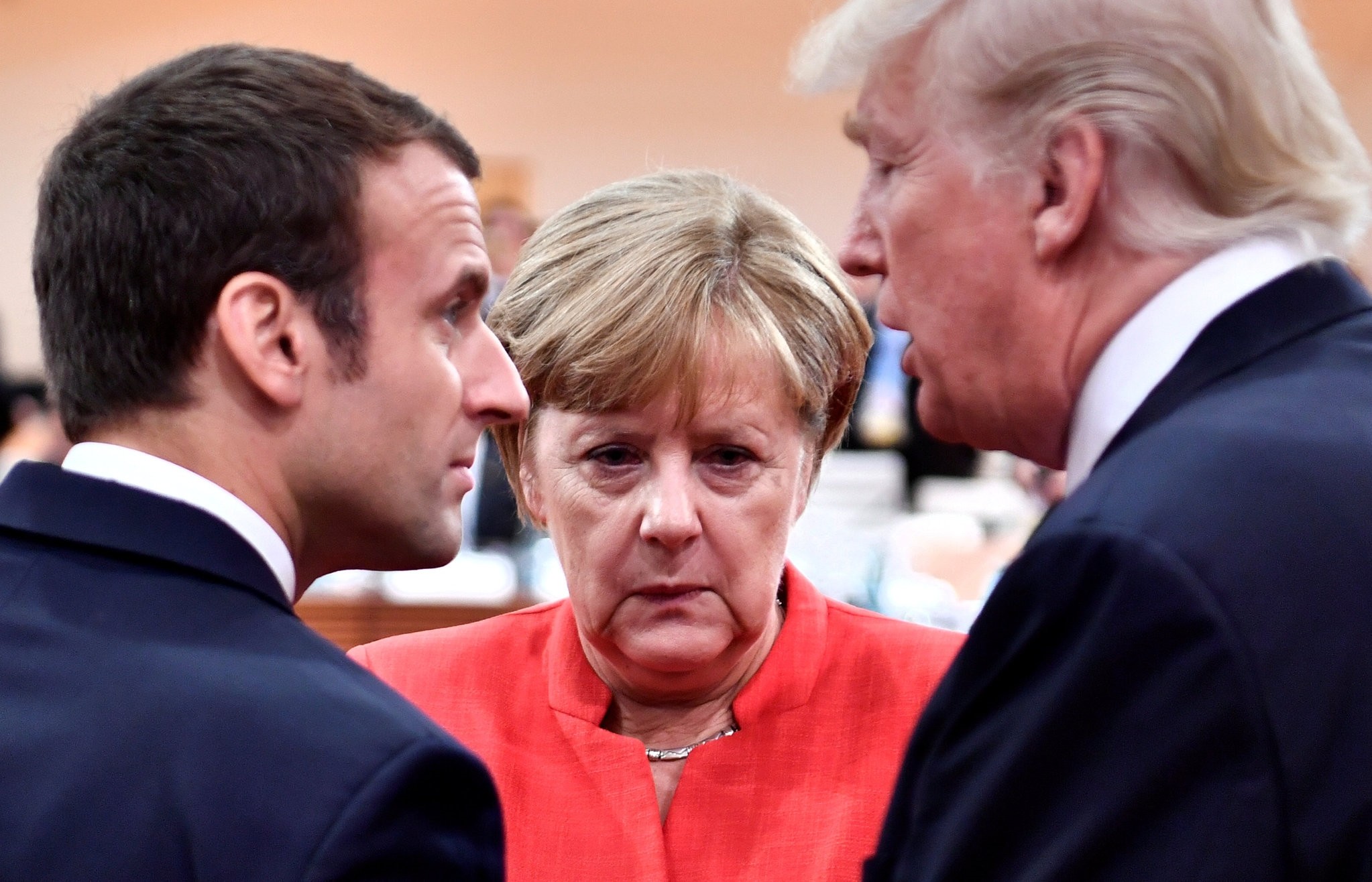 French President Emmanuel Macron, German Chancellor Angela Merkel and U.S. President Donald Trump confer at the start of the first working session of the G20 meeting in Hamburg, July 7, 2017.