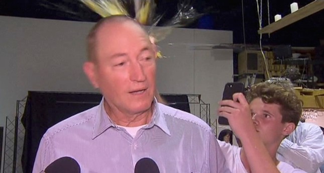 In this image made from video, a teenager breaks an egg on the head of Senator Fraser Anning while he holds a press conference, Saturday, March 16, 2019 (AP Photo)