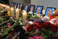 Flowers and candles are placed in front of portraits of the flight crew members of the Ukrainian 737-800 plane that crashed on the outskirts of Tehran, at a memorial inside Borispil International Airport outside Kyiv, Ukraine, Saturday, Jan. 11, 2020. (AP Photo)