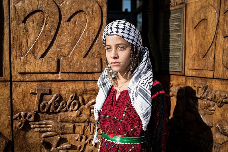 12-year-old Palestinian activist Janna Jihad, said to be the youngest journalist in the world, poses for pictures at the carved wooden entrance doors of the South African Constitutional Court in Johannesburg.