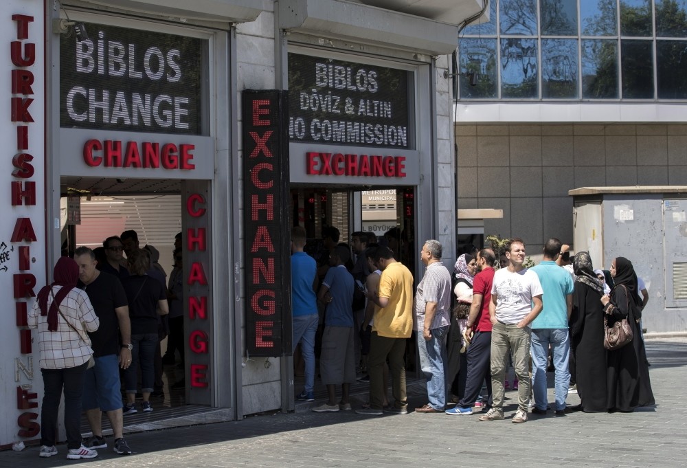 People exchange their money at a currency exchange office in Istanbul, Aug 13.