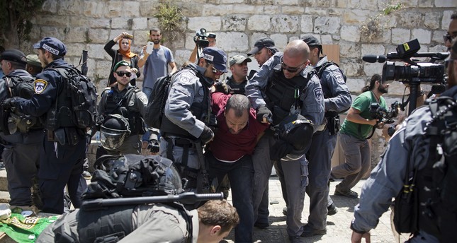 Israeli police officers detain a Palestinian man outside the Lion's Gate, following an appeal from clerics to pray in the streets instead of the Al Aqsa Mosque compound, in Jerusalem's Old City, Wednesday, July 19, 2017. (AP Photo)