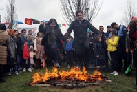 People leap over flames at a Nevruz event in Istanbul, March 21, 2019.