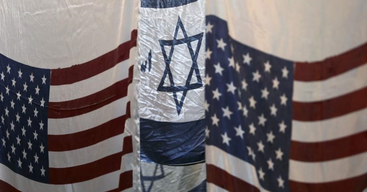 U.S. and altered Israeli flags hang at a large flag factory that creates them for Iranian protesters to burn in Khomein, Iran, Jan. 28, 2020. (West Asia News Agency via Reuters)