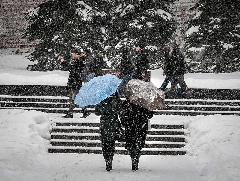 People walk with umbrellas during a snowfall in central Moscow, Russia, Feb. 3, 2018. (AFP Photo)