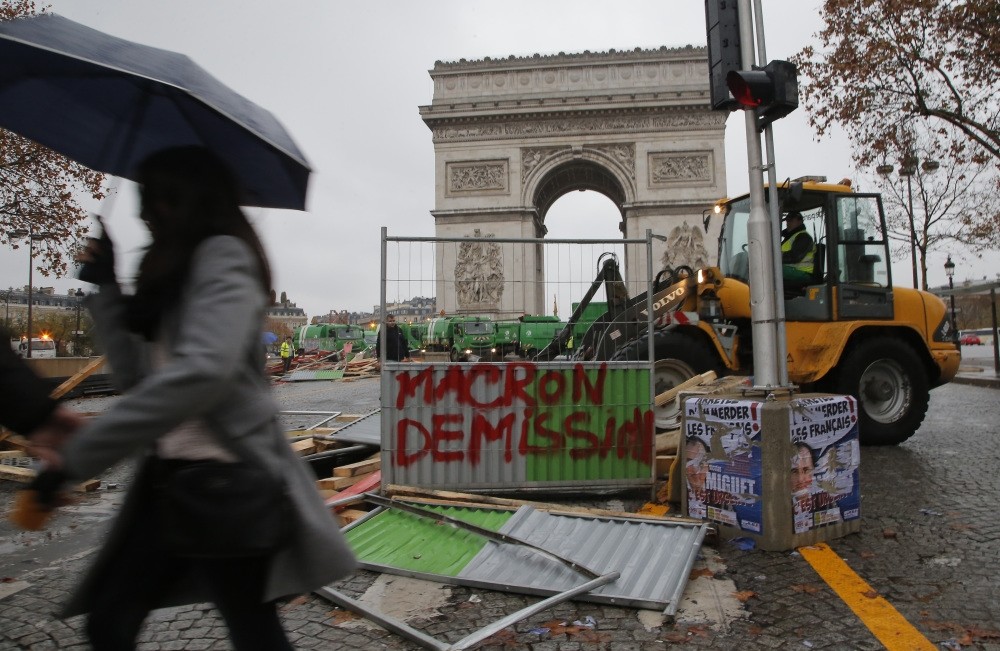 A bulldozer demolishes a makeshift barricade in the aftermath of a protest against rising fuel taxes on the Champs-Elysees avenue, Paris, Nov. 25.