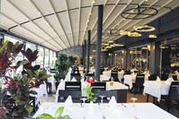 Yu00fcksel Balu0131k has brass lampshades, modern chandeliers, walls with mirrors and fresh orchids on the tables. 