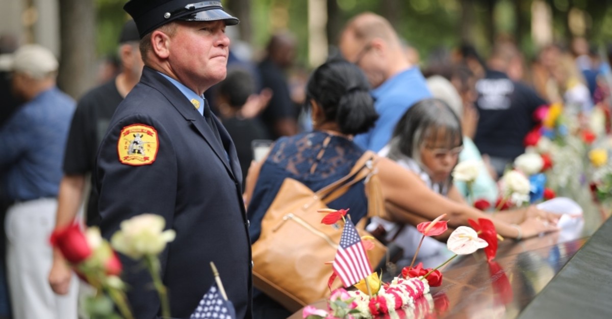 Friends and family of victims of the terrorist attacks, pause at the National September 11 Memorial during a morning commemoration ceremony for the victims of the terrorist attacks 18 years after the day on Sept. 11, 2019 in NYC. (AFP Photo)