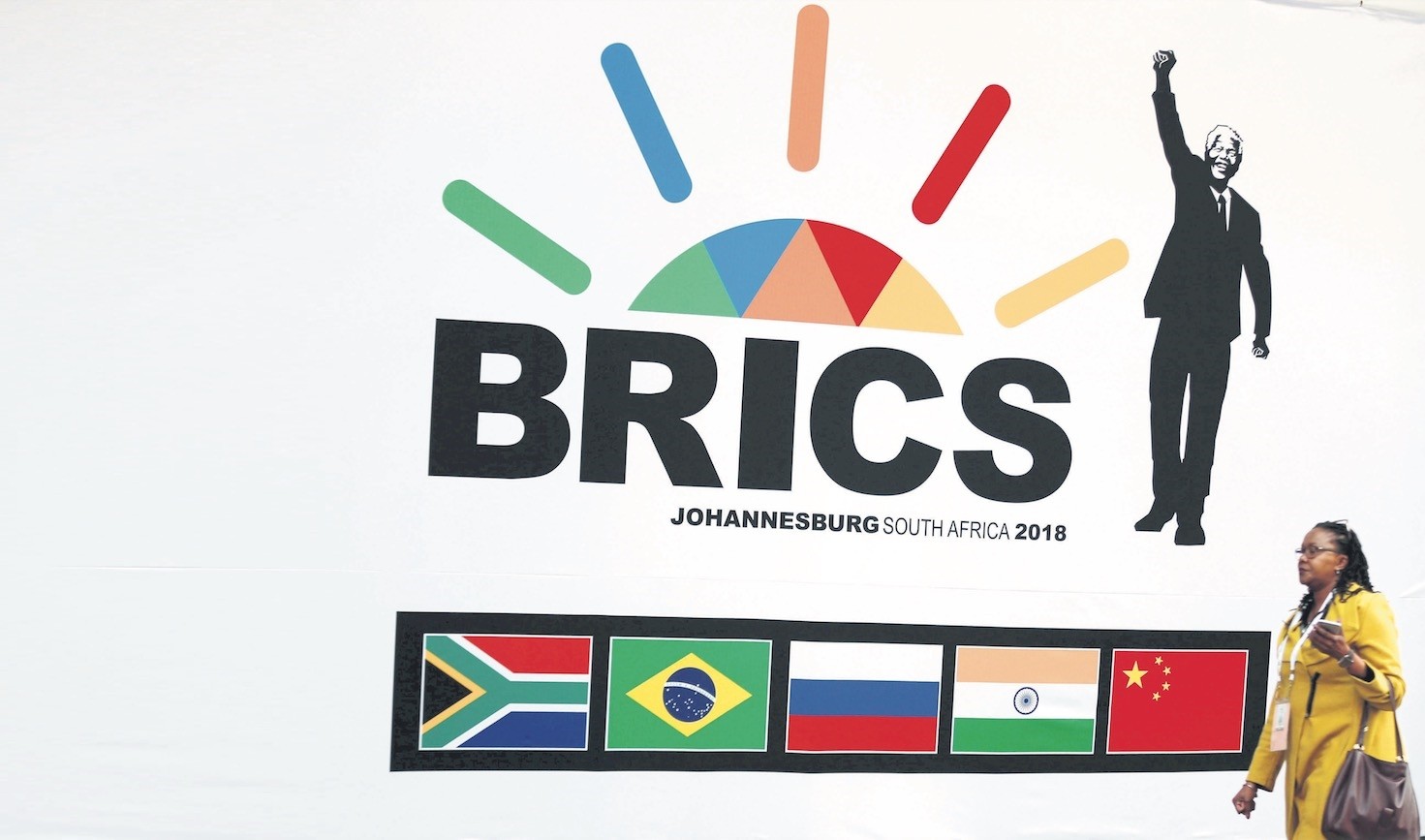 A delegate walks past a BRICS logo ahead of the 10th BRICS Summit, in Sandton, South Africa, July 24, 2018.