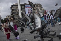 Pedestrians walk in front of a poster of President Recep Tayyip Erdou011fan, which reads ,Thank You, Istanbul,, two days after the June 24 presidential vote in 2018, in Taksim Square, Istanbul.