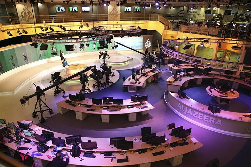 In this Jan. 1, 2015, file photo, staff members of Al-Jazeera International work at the news studio in Doha, Qatar. (AP Photo)