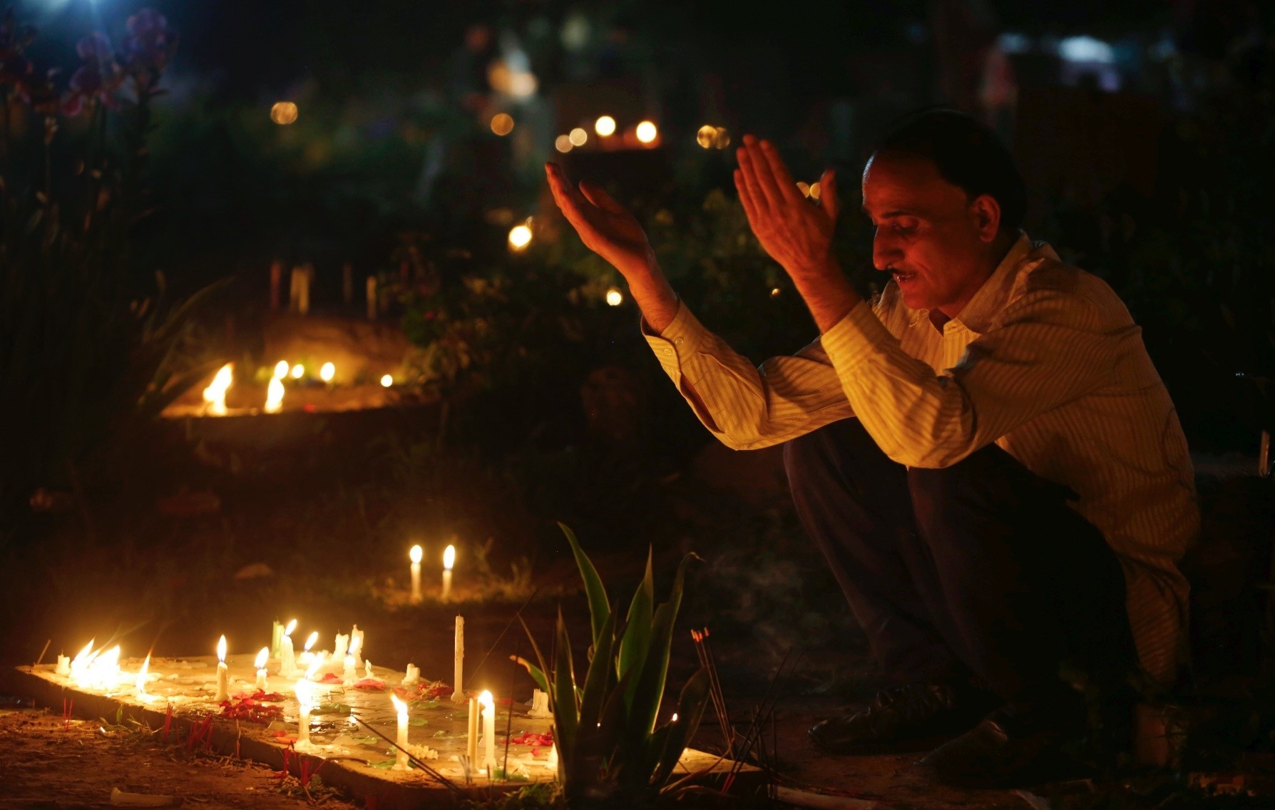 A Kashmiri Muslim prays as he lights candles at the grave of his relative to mark Shab-e-Barat, one of the holiest nights on the Islamic calendar.