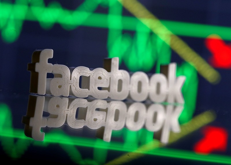A 3D-printed Facebook logo is seen in front of displayed stock graph in this illustration photo, March 20, 2018. (Reuters Photo)