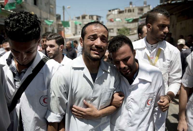 Palestinian paramedics mourn during the funeral of their colleague, Abdullah al-Qutati, who was shot and killed during the Friday's protest at the Gaza Strip's border with Israel, in town of Rafah, southern Gaza Strip, Aug.11, 2018. (AP Photo)