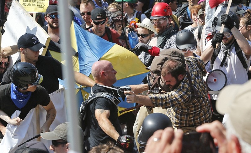 In this Aug. 12, 2017 file photo, white nationalist demonstrators clash with counter demonstrators at the entrance to Lee Park in Charlottesville, Va. (AP Photo)