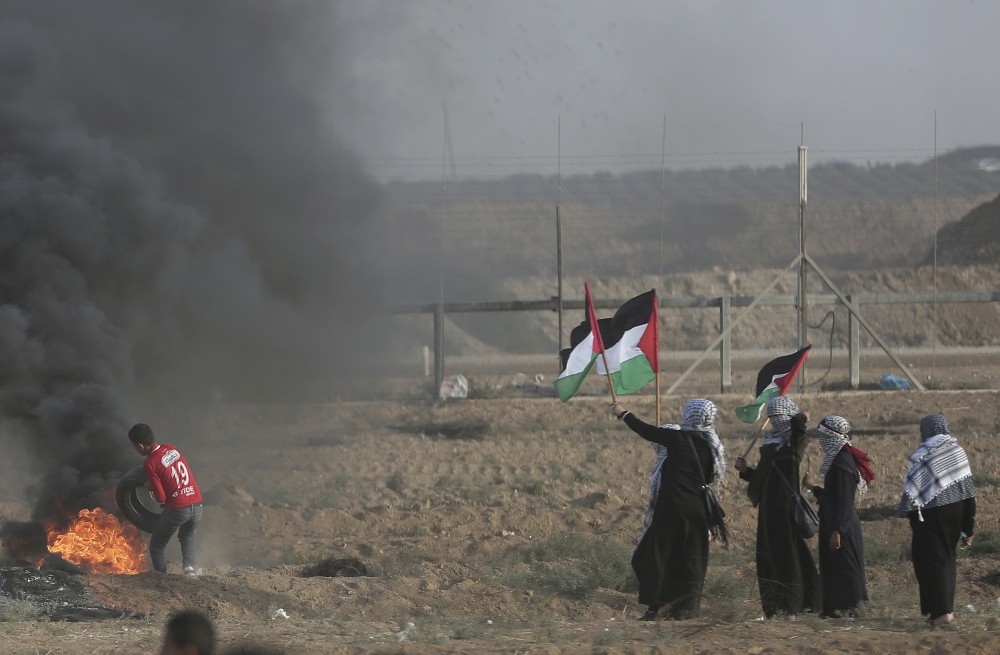 Palestinian women wave national flags during a protest at Gaza Strip's border with Israel, Oct. 5.