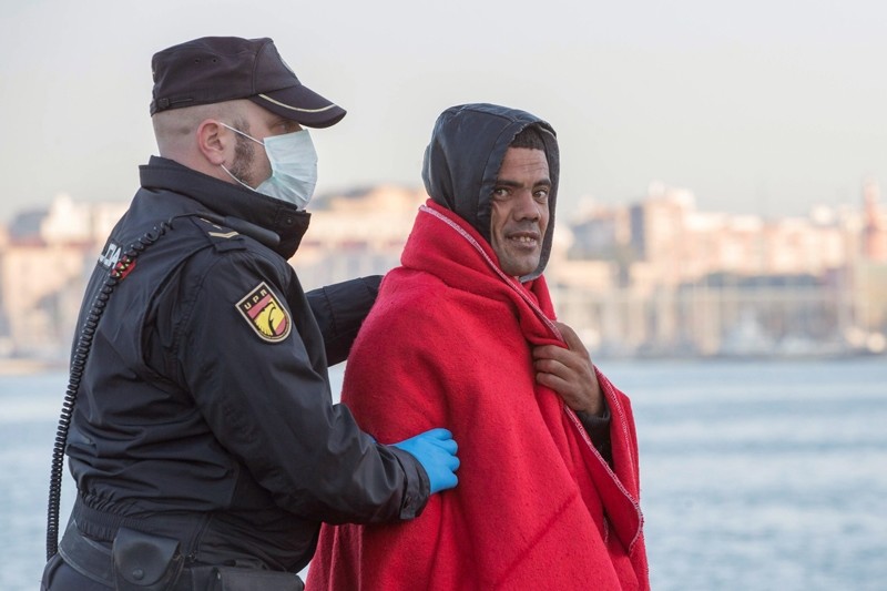 Spanish police officer escorts one of the 470 illegal migrants who were intercepted when they tried to reach Spanish territory in Murcia, southeastern Spain, Nov.18, 2017 ( EPA Photo)