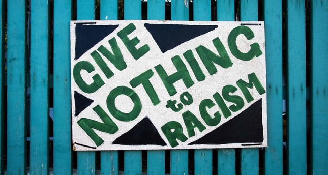 A placard that reads give nothing to racism is seen on a picket fence in Wellington on March 22, 2019, a week after the twin mosque massacre in Chrishchurch, New Zealand.