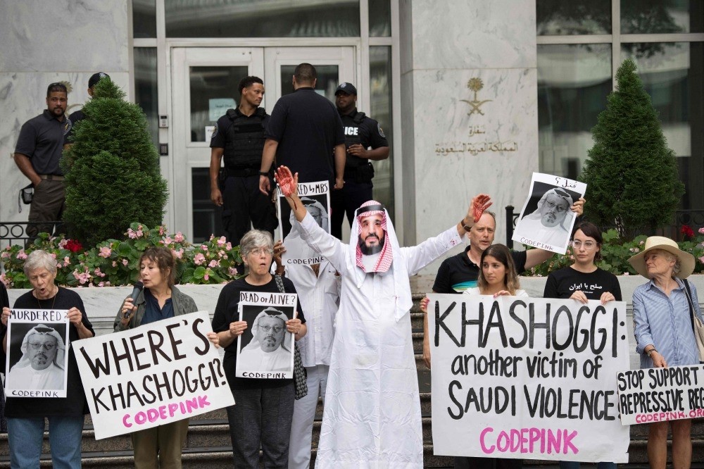 A demonstrator dressed as Saudi Arabian Crown Prince Mohammed bin Salman (C) with blood on his hands protests with others outside the Saudi Embassy in Washington, DC, on Oct. 8, demanding justice for missing Saudi journalist Jamal Khashoggi.