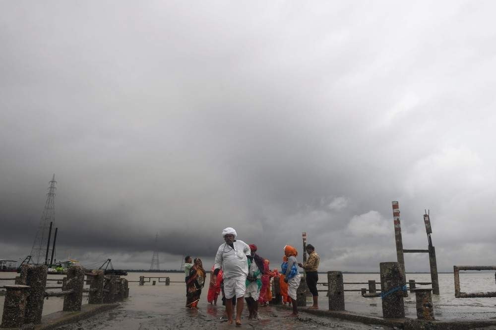 Hindu pilgrims walk back from the dock after a ferry service to Sagar Island was suspended due to the approaching Cyclone Bulbul in Kakdwip in West Bengal state on Nov. 9, 2019 (AFP Photo)