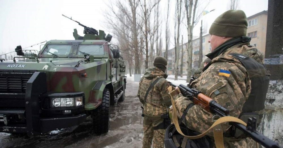 Ukrainian servicemen stand near their armed personal carrier in the eastern city of Avdiivka, Donetsk. 