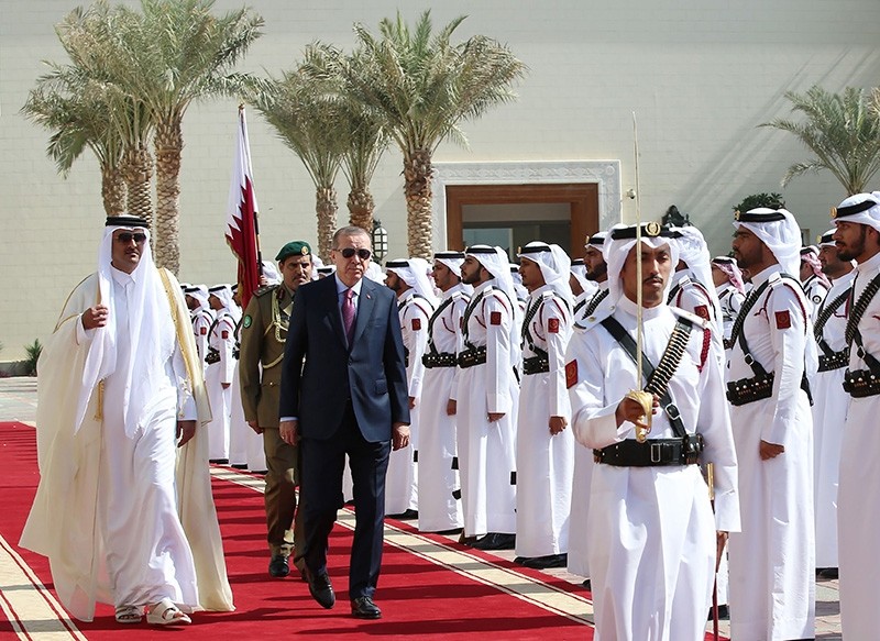 President Recep Tayyip Erdogan (C-L) being welcomed by Qatar's Emir Sheikh Tamim bin Hamad Al-Thani (L) as they review an honour guard upon his reception in the capital Doha. (AFP Photo)