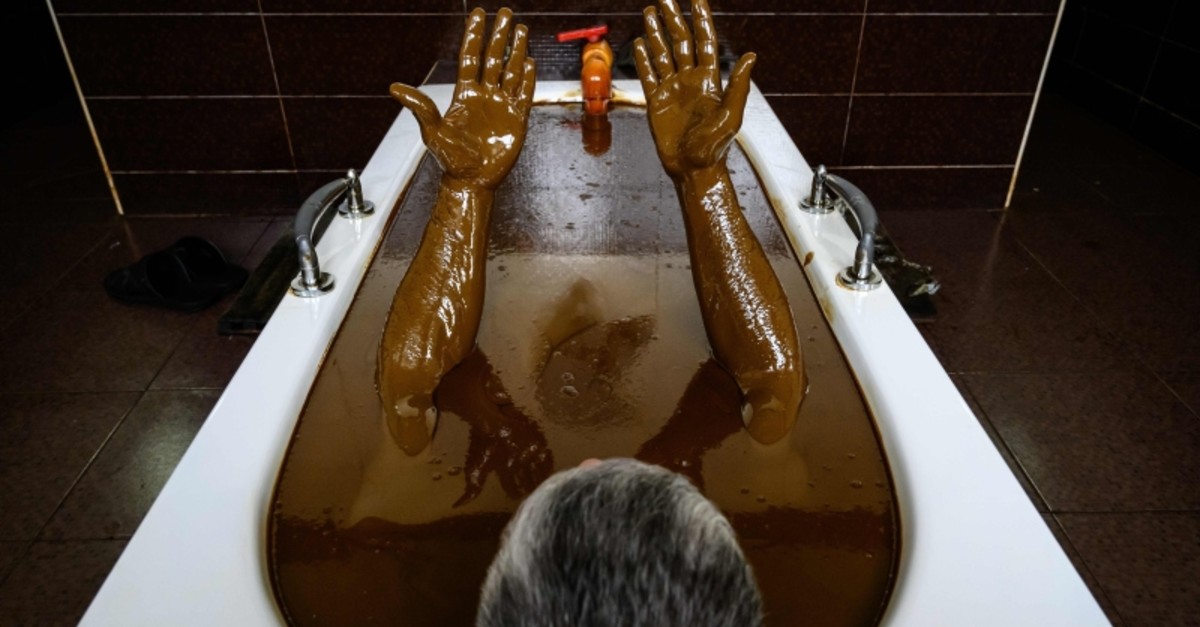 A man bathes in a tub filled with Naftalan crude oil during a treatment session at Sehirli Naftalan Health Center, some 300 kilometers (186 miles) from capital Baku, on March 21, 2019. (AFP Photo)
