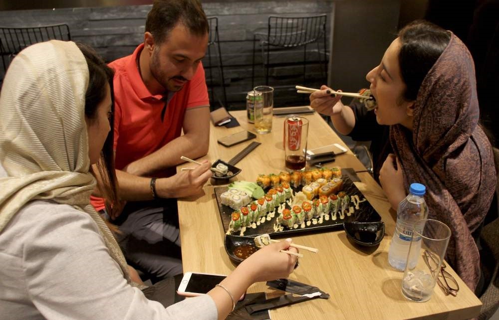 Iranians eat at a high-end French sushi chain that opened the previous week in northern Tehran.